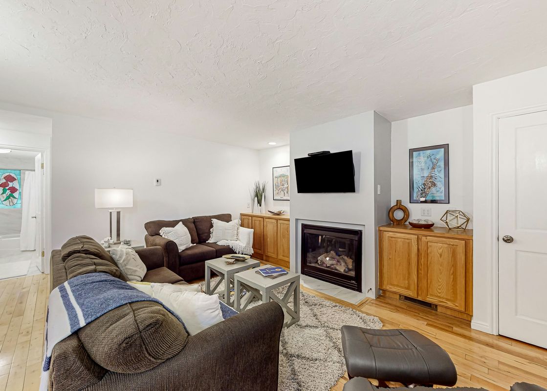 The living room of Emerald Pines at Motherlode C features a fireplace, TV, and comfortable seating.