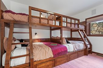 A charming bedroom featuring a custom-built wooden bunk bed at Abode on the Big Trail.