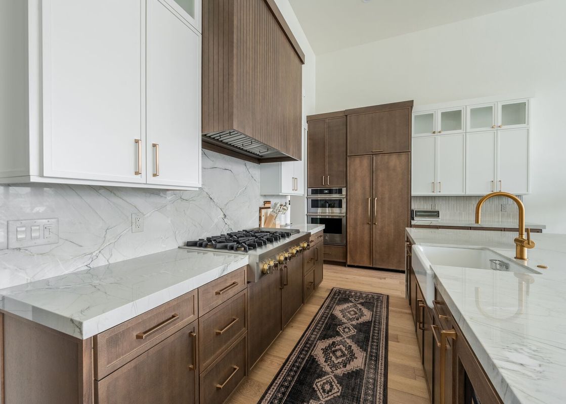 Modern gourmet kitchen at 1725 Amanti Lago with custom cabinetry, marble countertops, and built-in appliances.