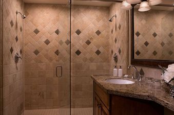 Elegant bathroom in the Teton Mountain Lodge Alpine Studio showing a double-head walk-in shower and granite vanity.