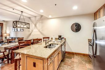A kitchen with stainless steel appliances, granite countertops, and wooden cabinets.