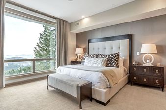 Elegant bedroom at Stein Eriksen Lodge Premium Luxury 4 Bedroom Suite with Hot Tub featuring a king bed and large windows overlooking the mountains.