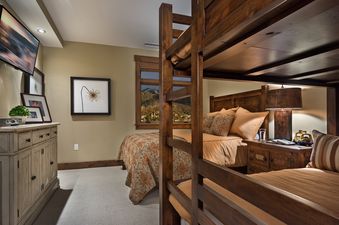 The bunk room at Sugar Loaf Mountain One Steamboat Place 703 features warm wooden bunk beds and an additional twin bed, creating a cozy and inviting space for multiple guests.