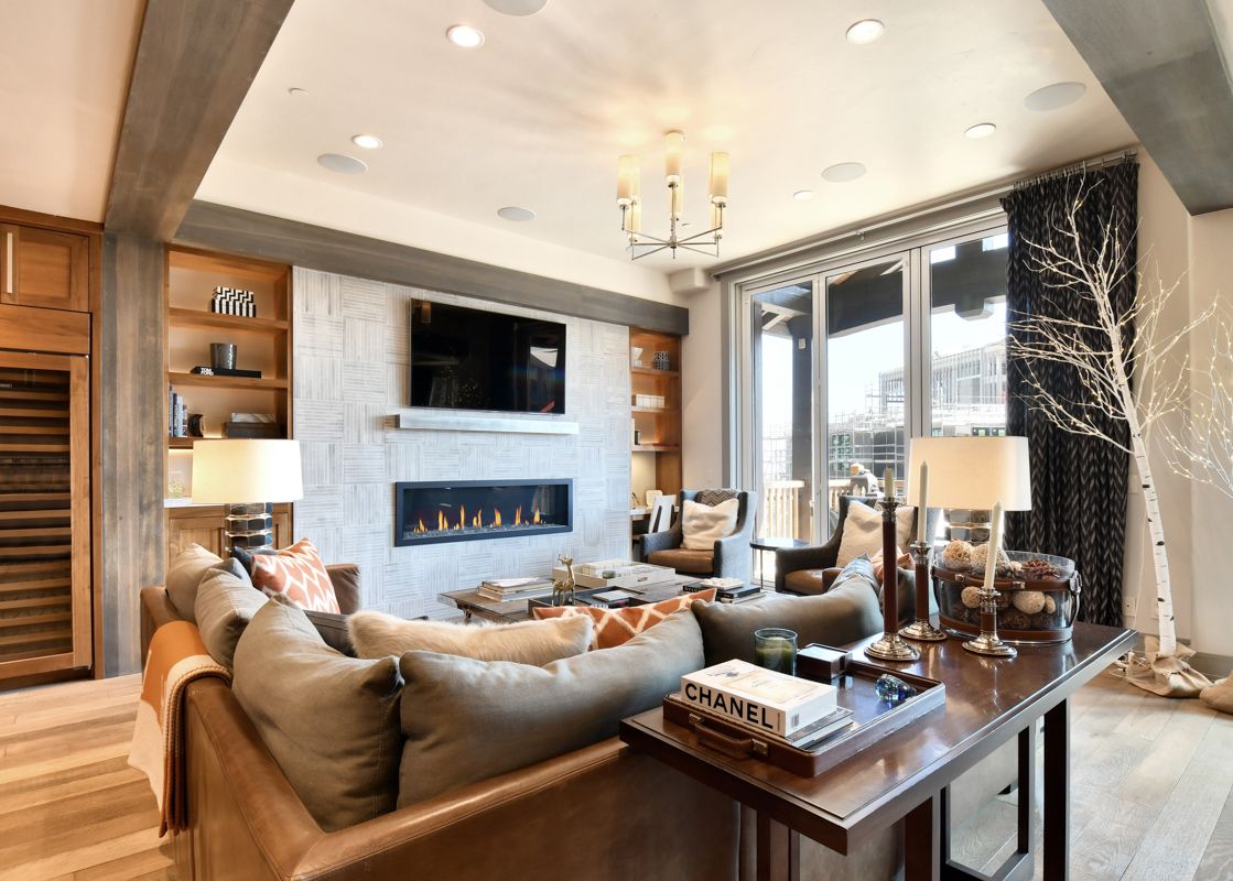 A luxurious living room in the Silver Strike Lodge 602 Presidential Suite with a modern fireplace, flat-screen TV, and plush seating.