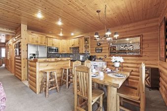 The dining area in Black Bear 207 features a rustic wooden table and chairs.