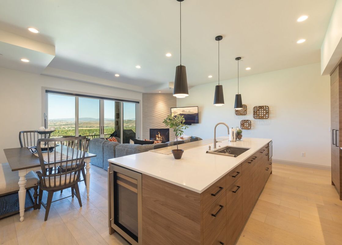 A modern open-concept kitchen and living area with mountain views from Juniper 801.