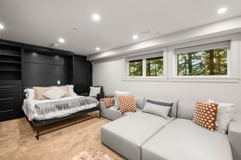 A modern basement living area featuring a comfortable sofa and a convenient pull-out bed, perfect for relaxation and accommodating guests.