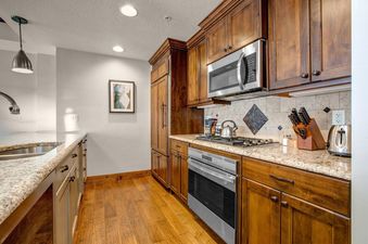 The kitchen at Abode at First Dawn B features custom cabinetry and stainless steel appliances.