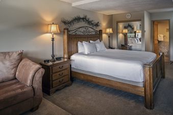 The master bedroom features a king-sized bed, two nightstands with lamps, and an armchair, all contributing to a comfortable and elegant atmosphere.