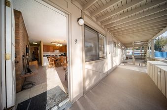 A wide-angle view from the outdoor walkway of Hi Country Haus 309 showing the entrance to the unit with the kitchen and dining area visible inside.