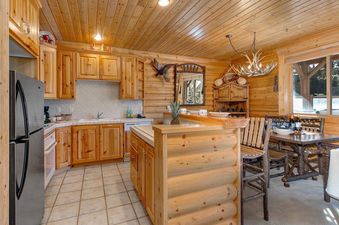 The kitchen area of Black Bear 305 Abode features wood finishings and an antler chandelier.