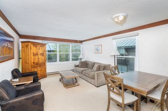 The living area of Mountainside Inn 413 features a cozy seating arrangement and natural light.