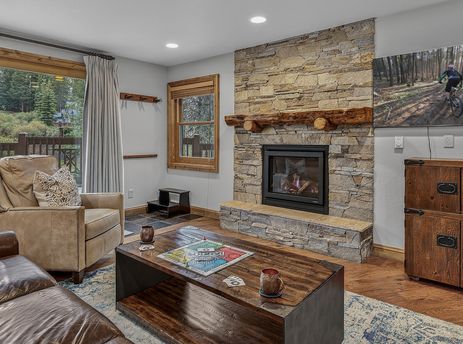 Inviting living room with a stone fireplace and leather seating at First Tracks Chalet.