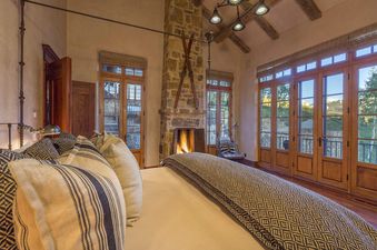 Bedroom with a king-size bed, a fireplace, and views of the mountains.