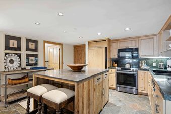 A kitchen with wood cabinets, a large island, and stainless steel appliances
