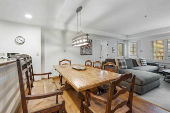 The dining area of Lodge Tower 487 3 Bedroom features a rustic wooden table and chairs.
